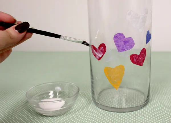 a photo of a diy photo vase: gluing on tissue paper hearts