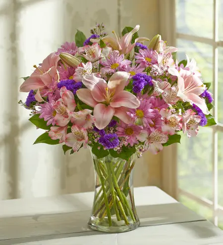 Flower arrangement with pink lilies, alstroemeria, daisies and purple accents
